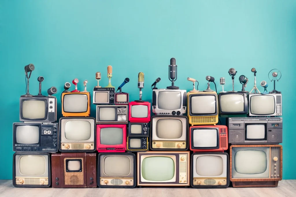 Many vintage televisions, stacked